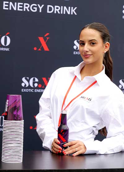 ragazza in camicia bianca sorridente con bottiglia sexo in mano